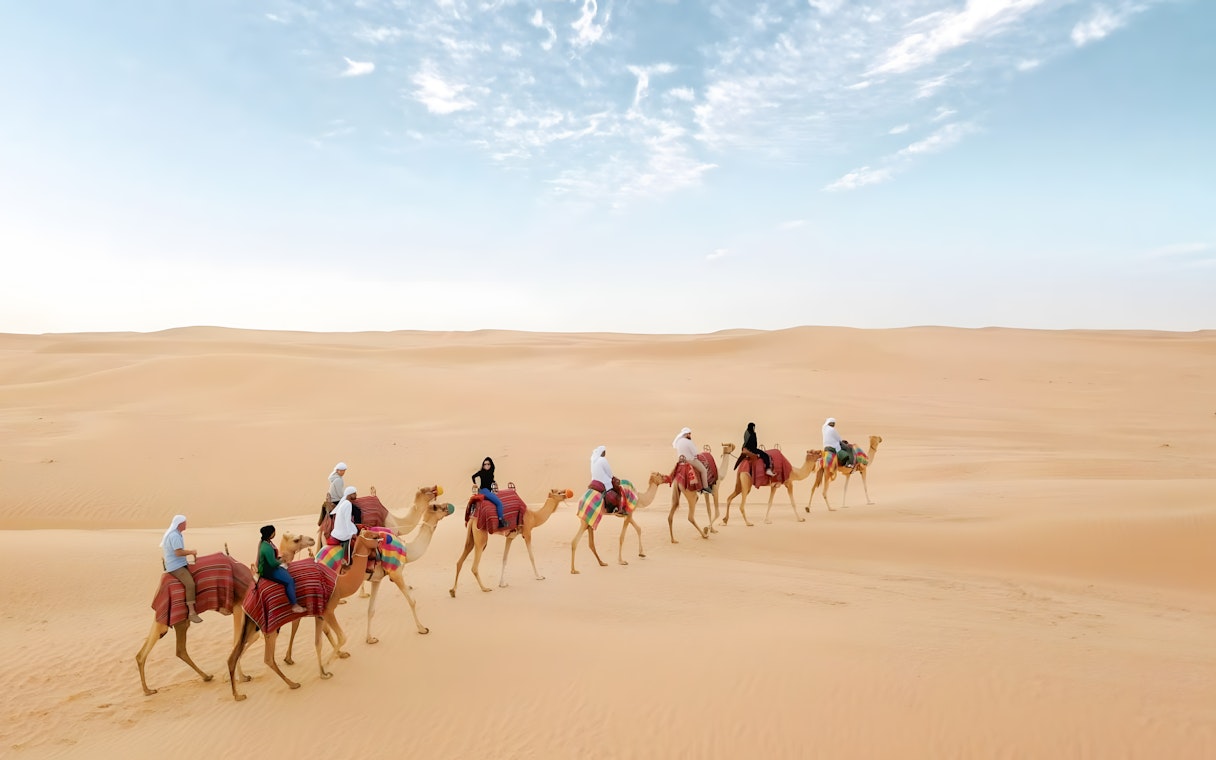 Camel ride through desert dunes at Bedouin Culture Safari, Dubai.