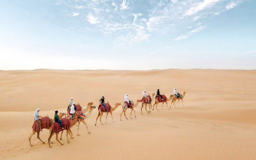 Camel ride through desert dunes at Bedouin Culture Safari, Dubai.