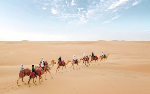Camel ride through desert dunes at Bedouin Culture Safari, Dubai.