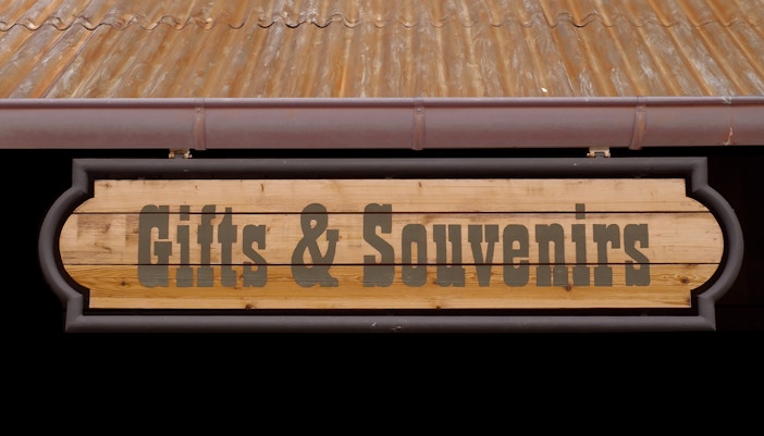 Western-themed gift shop sign in a rustic setting.