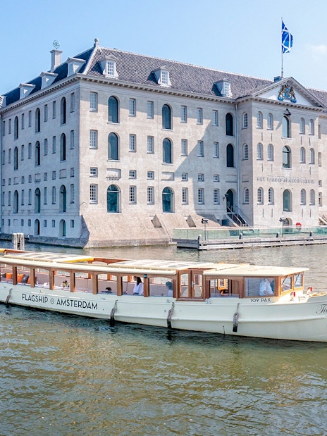 Amsterdam canal cruise boat passing the National Maritime Museum.