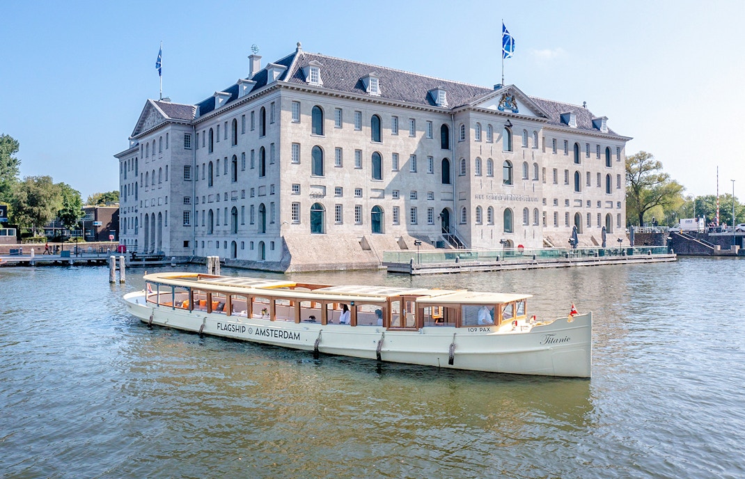 Amsterdam canal cruise boat passing the National Maritime Museum.