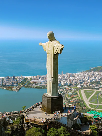 Christ the Redeemer statue overlooking Rio de Janeiro with cityscape and ocean in the background.