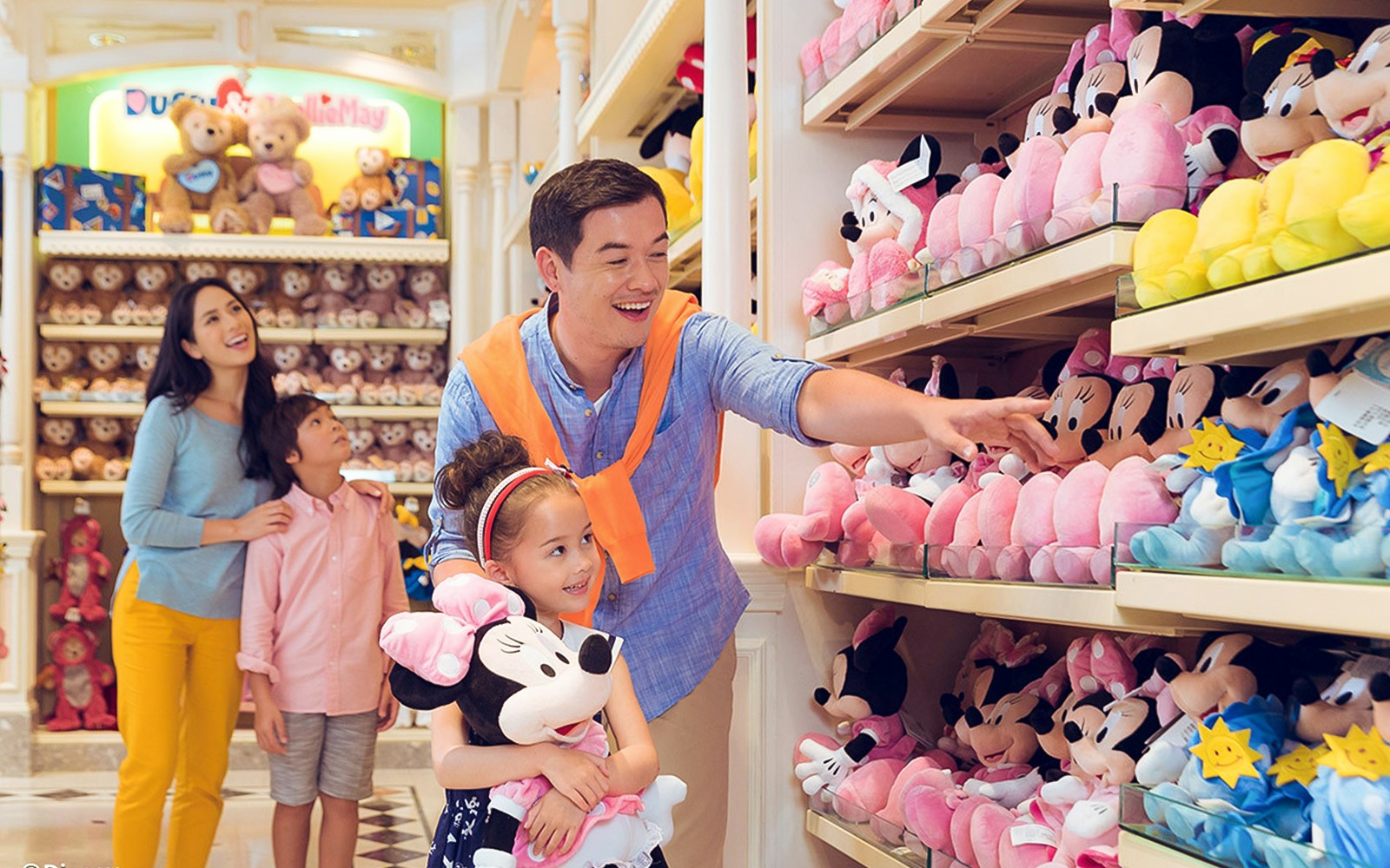 Family shopping for plush toys at Hong Kong Disneyland store.
