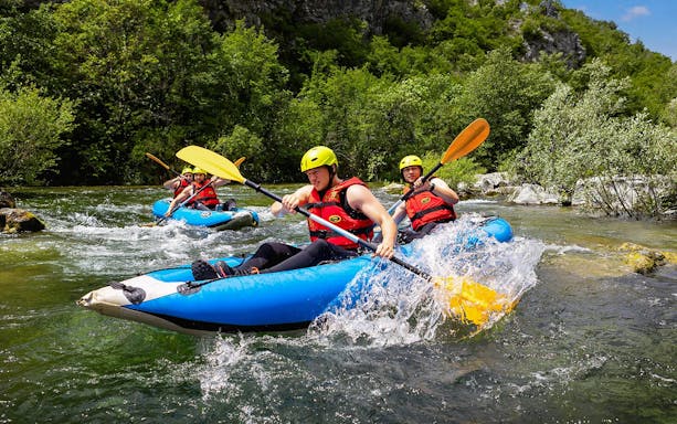 Rafting group navigating river rapids near Split, Croatia.