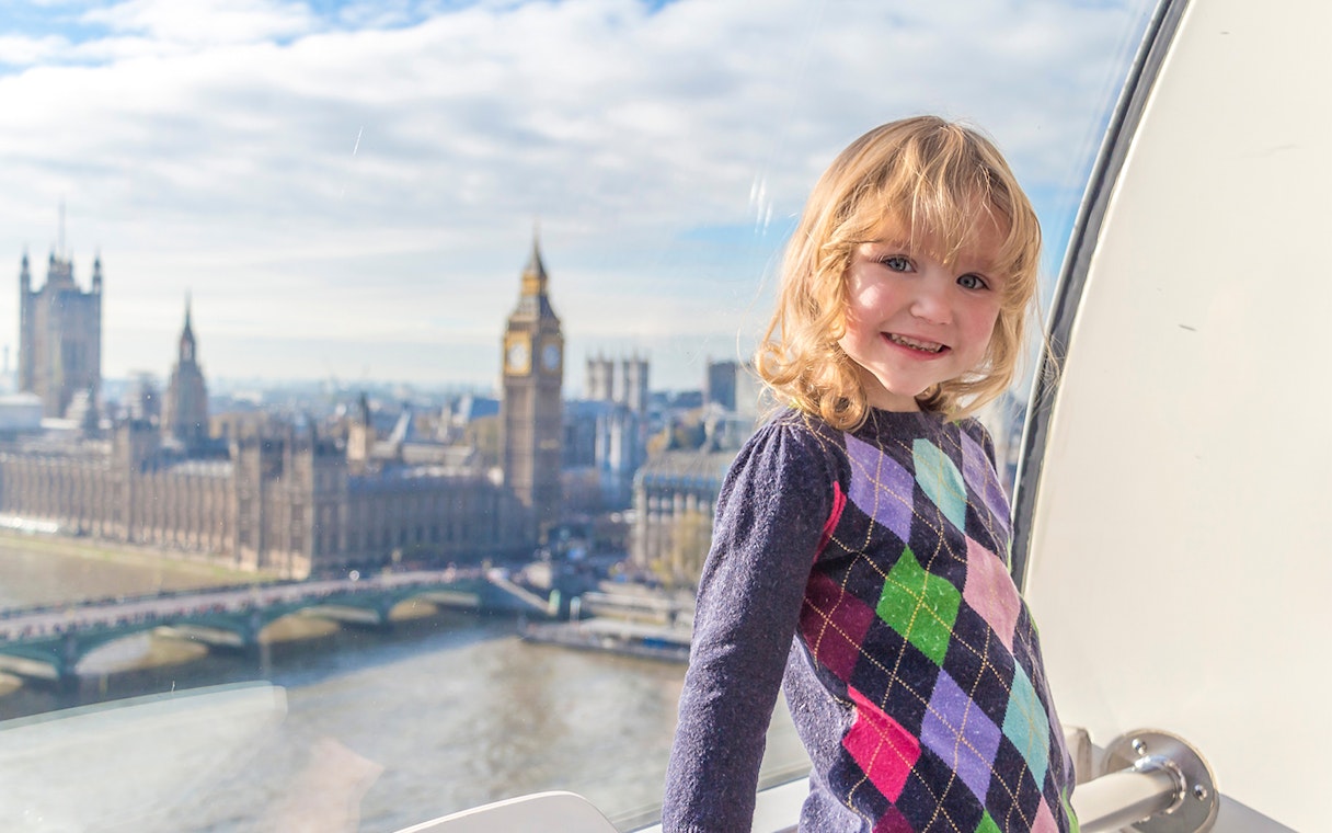 Child enjoying view of Big Ben and Houses of Parliament from London Eye capsule.