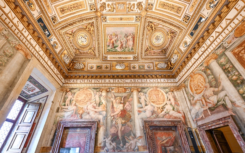 Interior of Castel Sant'Angelo with ornate ceiling and detailed frescoes in Rome, Italy.