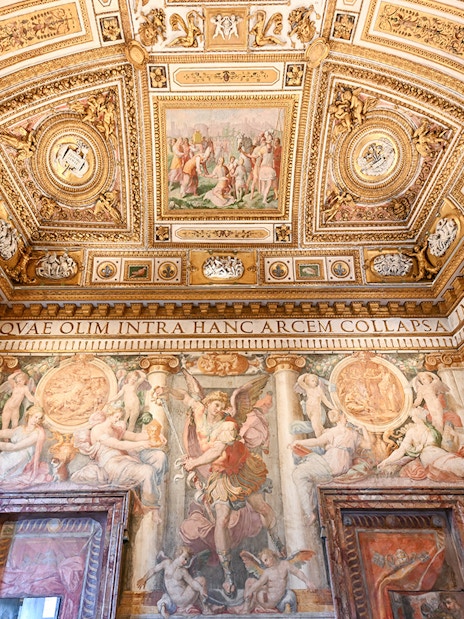 Interior of Castel Sant'Angelo with ornate ceiling and detailed frescoes in Rome, Italy.