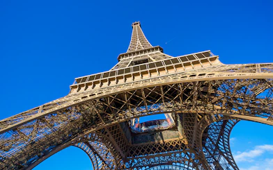 Eiffel Tower viewed from below against a clear blue sky, Paris.
