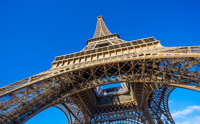 Eiffel Tower viewed from below against a clear blue sky, Paris.