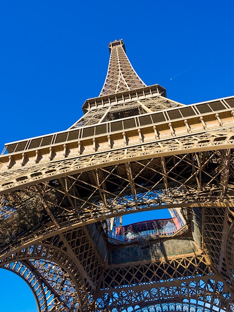 Eiffel Tower viewed from below against a clear blue sky, Paris.