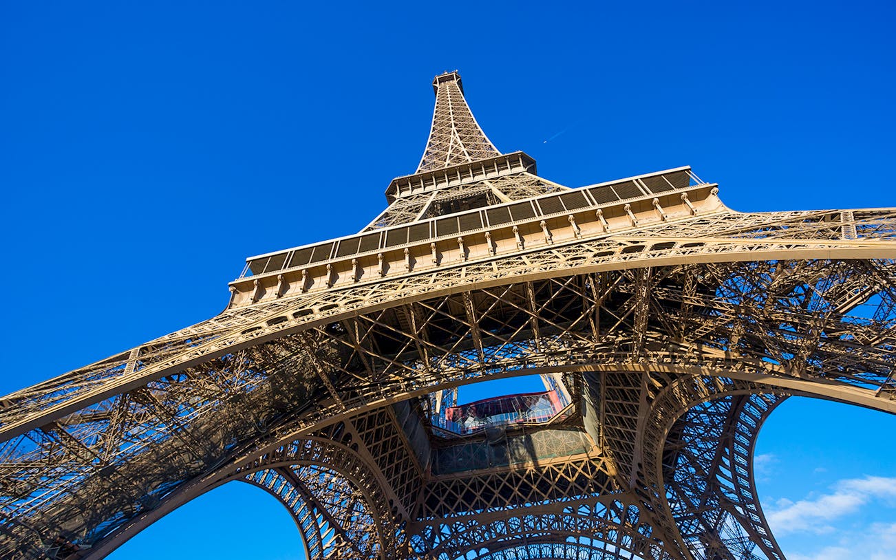 Eiffel Tower viewed from below against a clear blue sky, Paris.