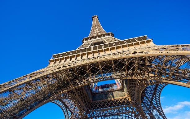 Eiffel Tower viewed from below against a clear blue sky, Paris.