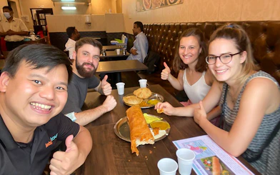 Group enjoying Indian food on a guided tasting tour in Little India Hawker Street, Singapore.
