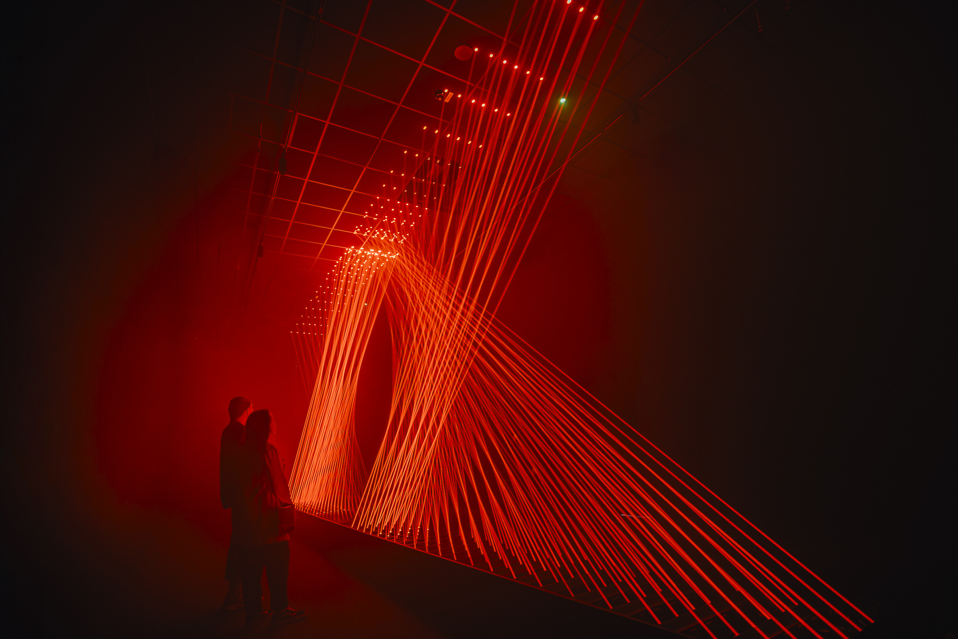 Guests viewing red light installation at Signal Space Digital Art Gallery.