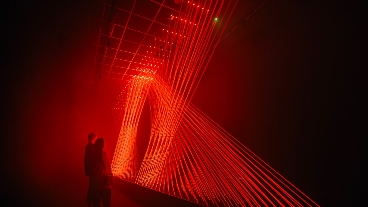Guests viewing red light installation at Signal Space Digital Art Gallery.