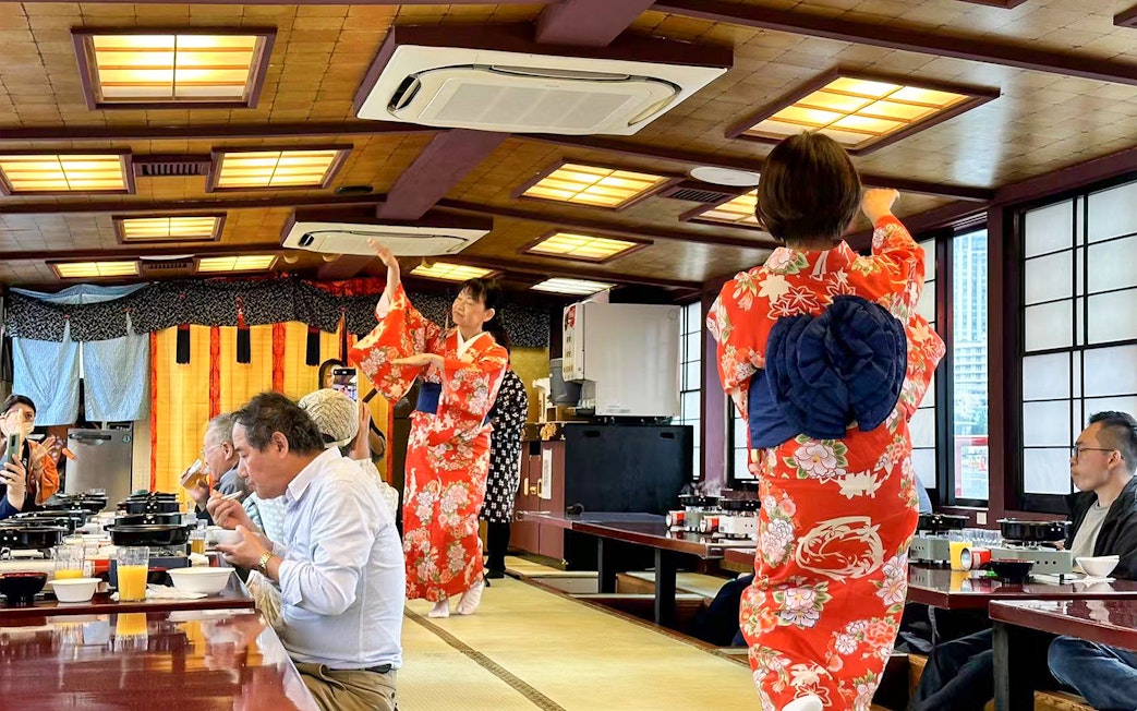 Yakatabune cruise with guests dining and performers in kimonos, Tokyo.