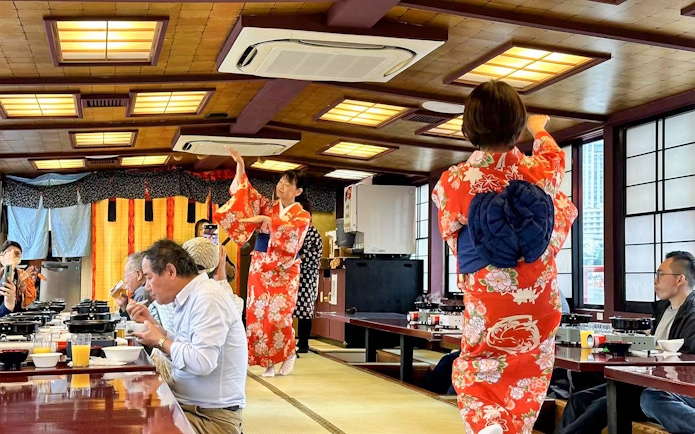 Yakatabune cruise with guests dining and performers in kimonos, Tokyo.