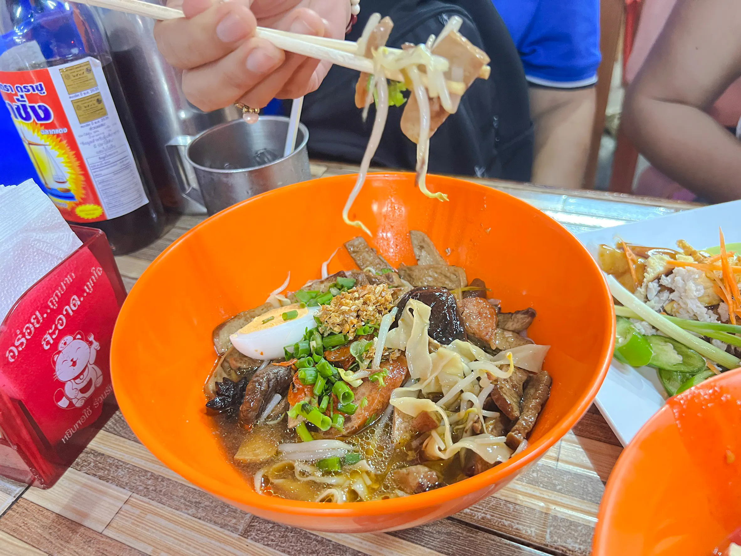 Chiang Mai street food bowl with noodles, mushrooms, and herbs on a Michelin food tour.