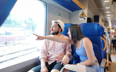 Couple enjoying scenic view from train window.