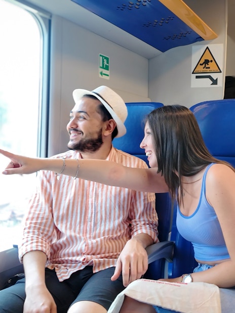 Couple enjoying scenic view from train window.
