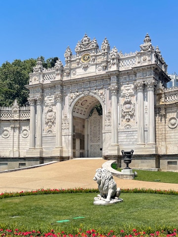 Dolmabahçe Palace gate with ornate architecture and lion statue, Istanbul.