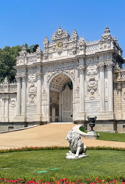 Dolmabahçe Palace gate with ornate architecture and lion statue, Istanbul.
