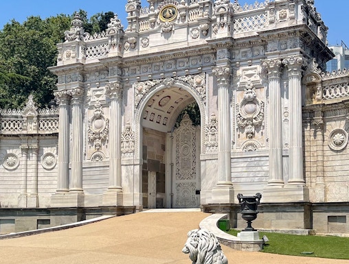 Dolmabahçe Palace gate with ornate architecture and lion statue, Istanbul.
