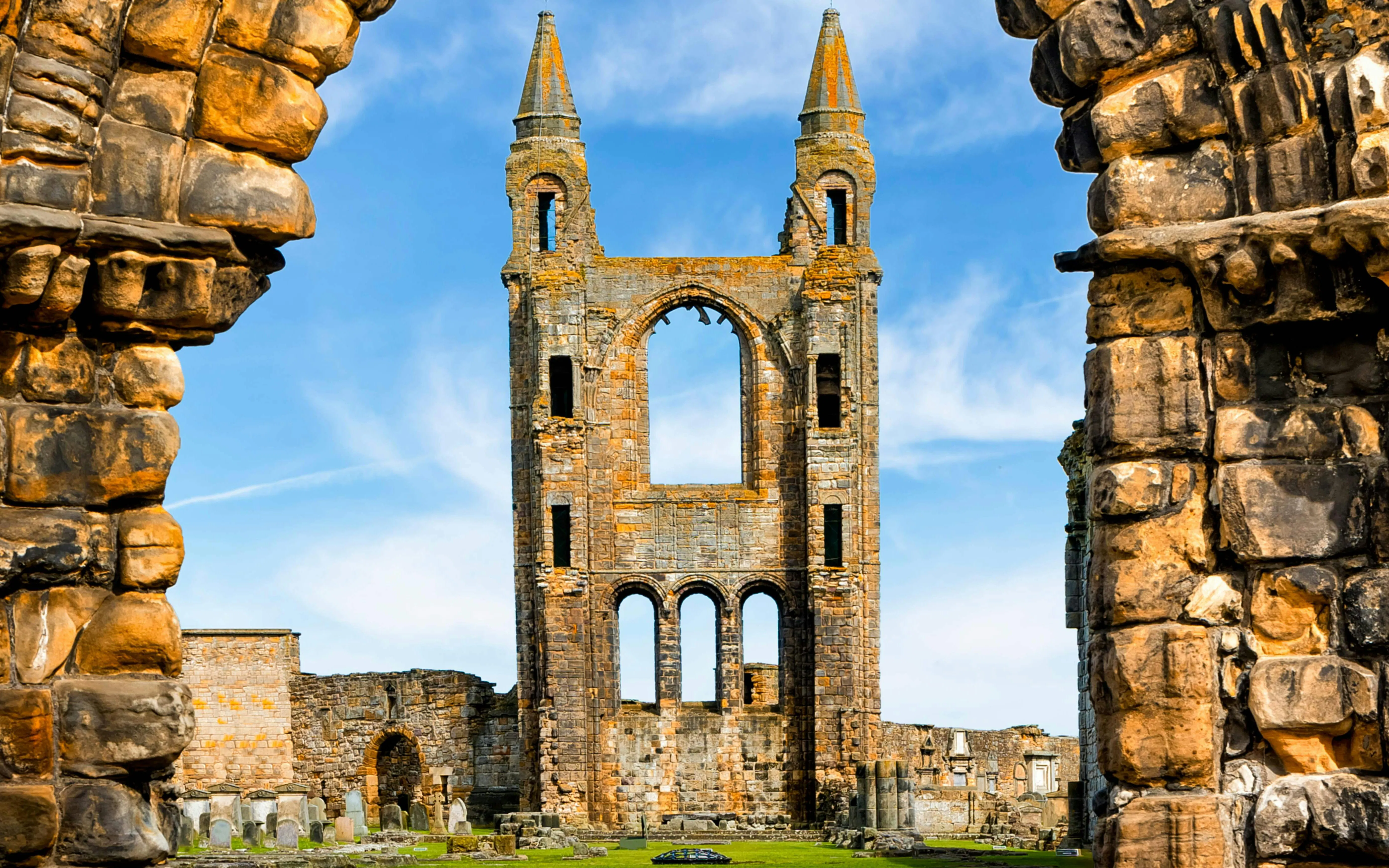 St Andrews Cathedral ruins with stone arches and gravestones in Scotland.