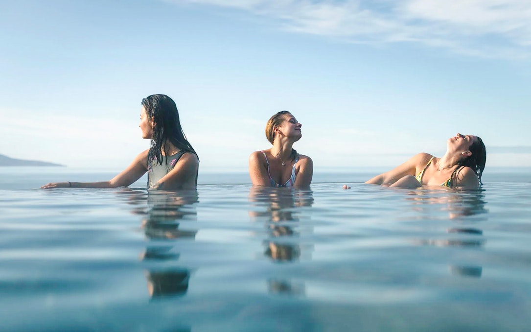 Guests enjoying Geosea Geothermal Baths with ocean view in Iceland.