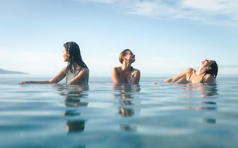 Guests enjoying Geosea Geothermal Baths with ocean view in Iceland.