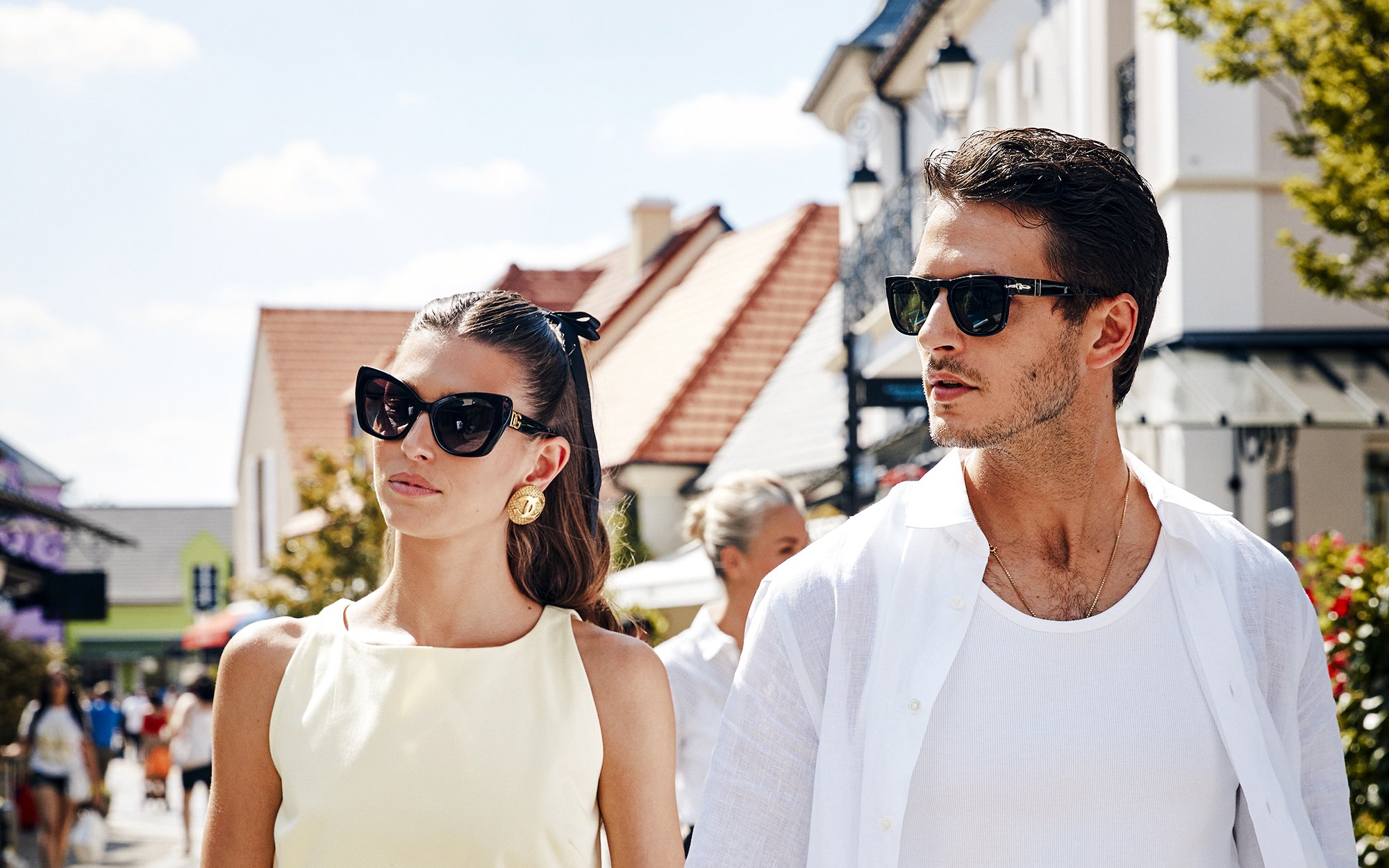 Couple walking in La Vallée Village, Paris, France shopping area.