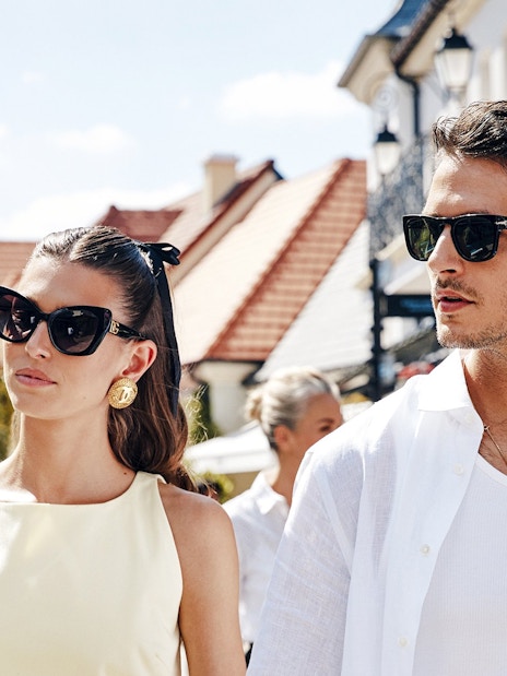 Couple walking in La Vallée Village, Paris, France shopping area.