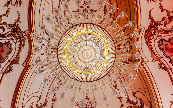 Chandelier at National Palace of Queluz with ornate ceiling details.