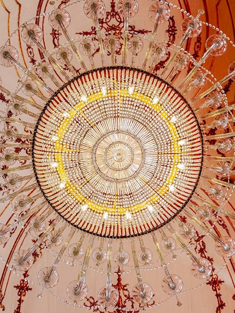 Chandelier at National Palace of Queluz with ornate ceiling details.