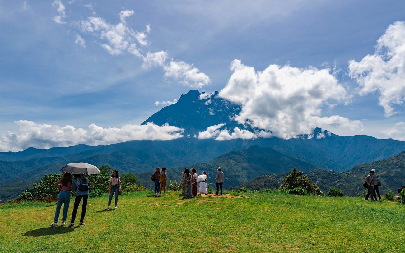 Visitors enjoying the view of Mount Kinabalu on a guided day tour.