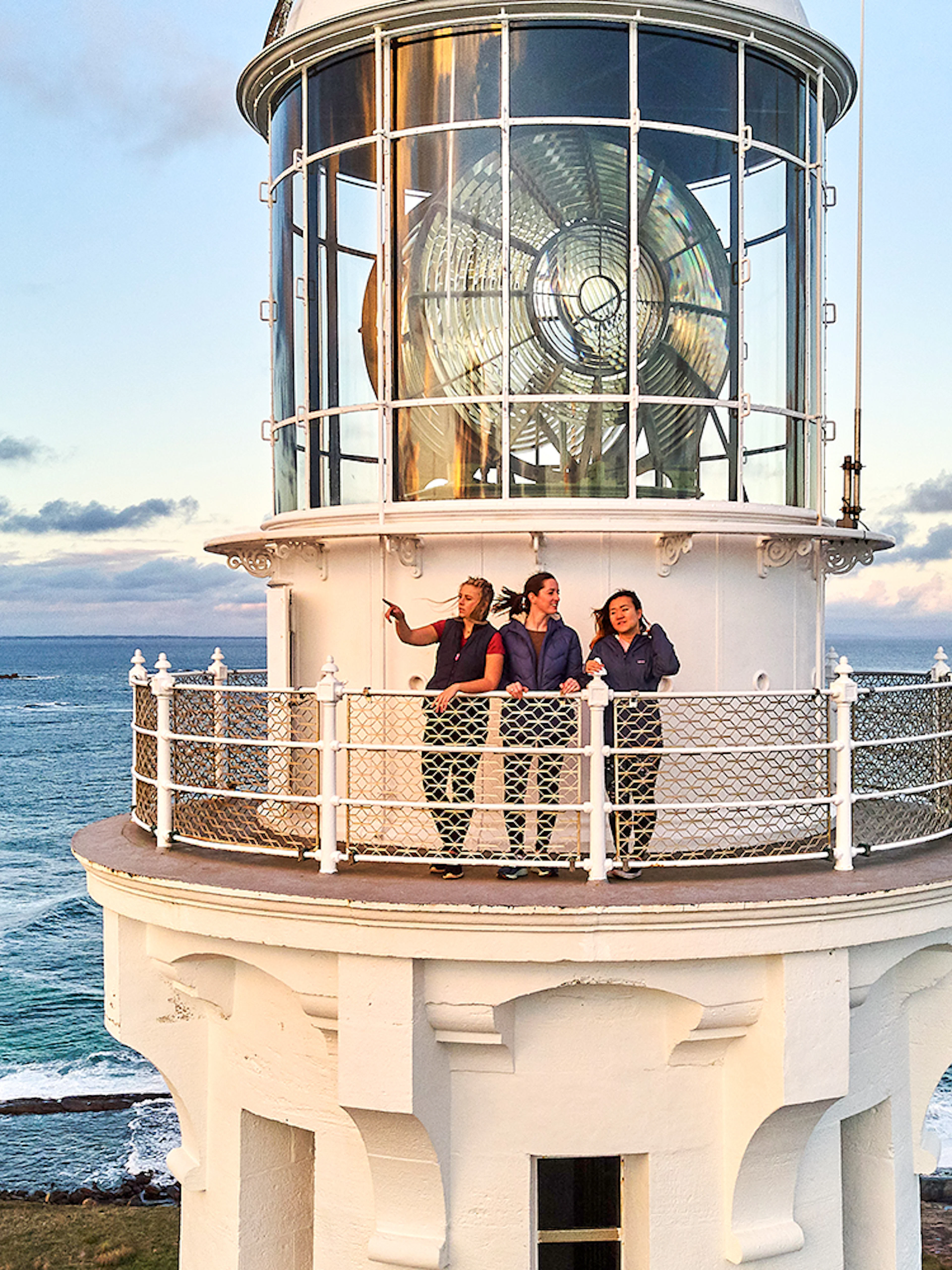 Visitors on Cape Leeuwin Lighthouse balcony overlooking ocean views.