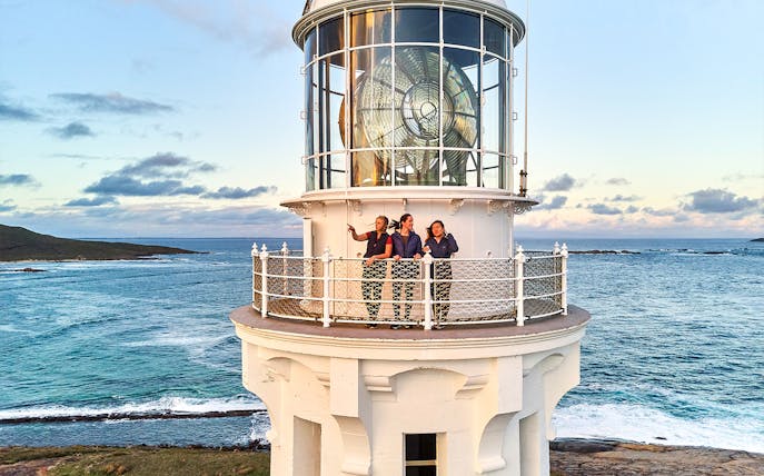 Visitors on Cape Leeuwin Lighthouse balcony overlooking ocean views.