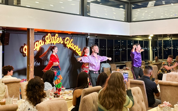 Dancers performing traditional Turkish show on Bosphorus dinner cruise with private tables.