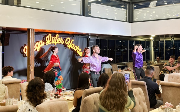 Dancers performing traditional Turkish show on Bosphorus dinner cruise with private tables.