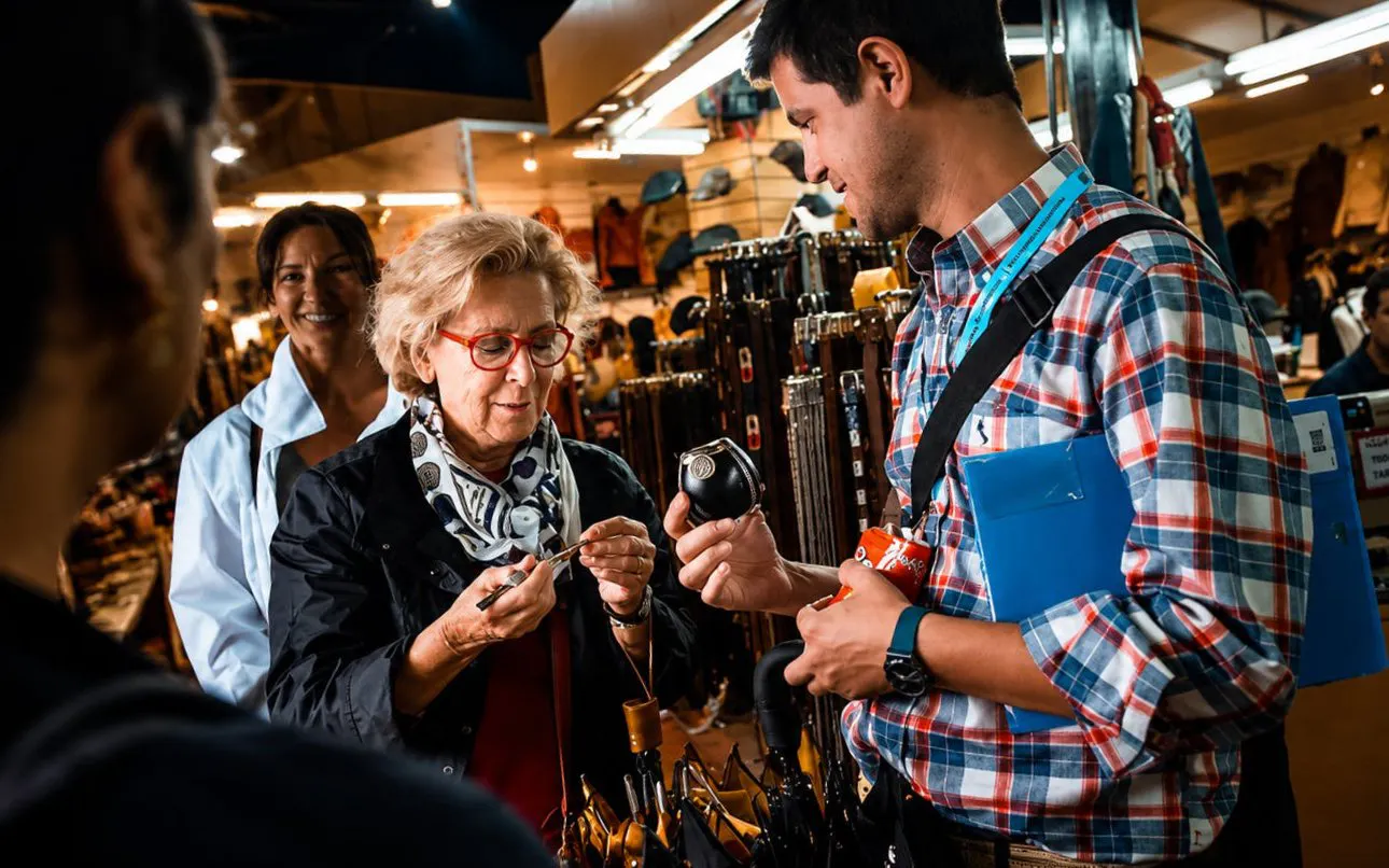 Tourists exploring a local market in Buenos Aires, examining traditional items.