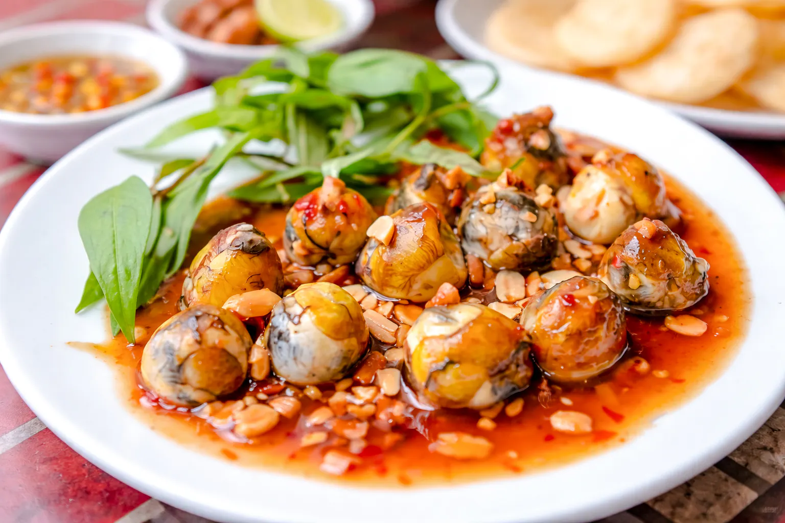 Hanoi street food dish with fertilized duck eggs in spicy sauce, garnished with herbs.