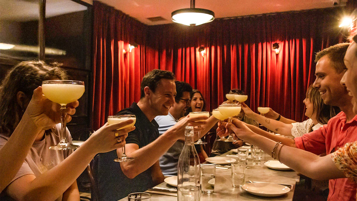Group toasting with cocktails during Eating London: Twilight Soho Food & Drinks Tour.
