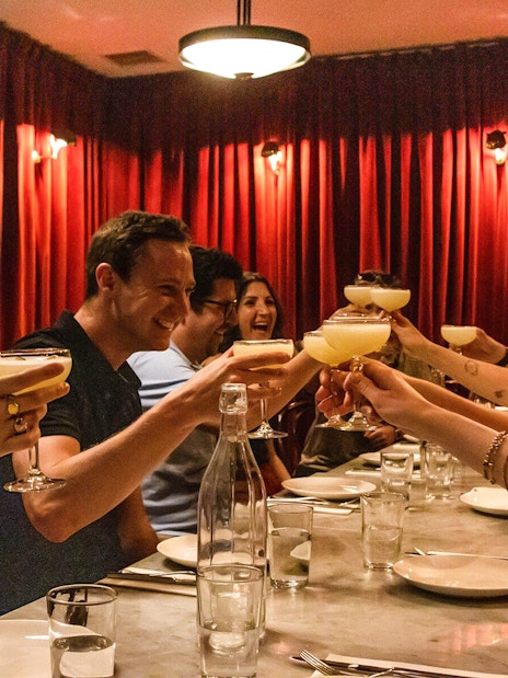 Group toasting with cocktails during Eating London: Twilight Soho Food & Drinks Tour.