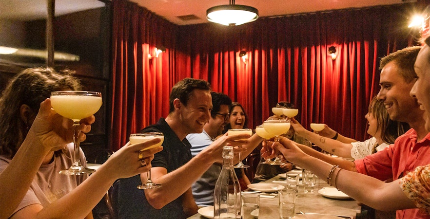 Group toasting with cocktails during Eating London: Twilight Soho Food & Drinks Tour.