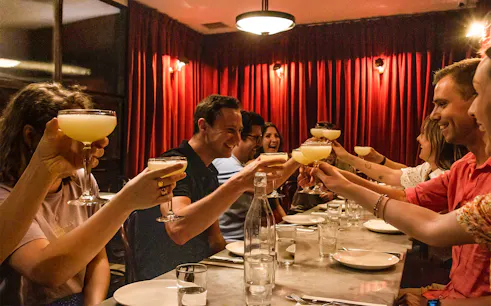 Group toasting with cocktails during Eating London: Twilight Soho Food & Drinks Tour.