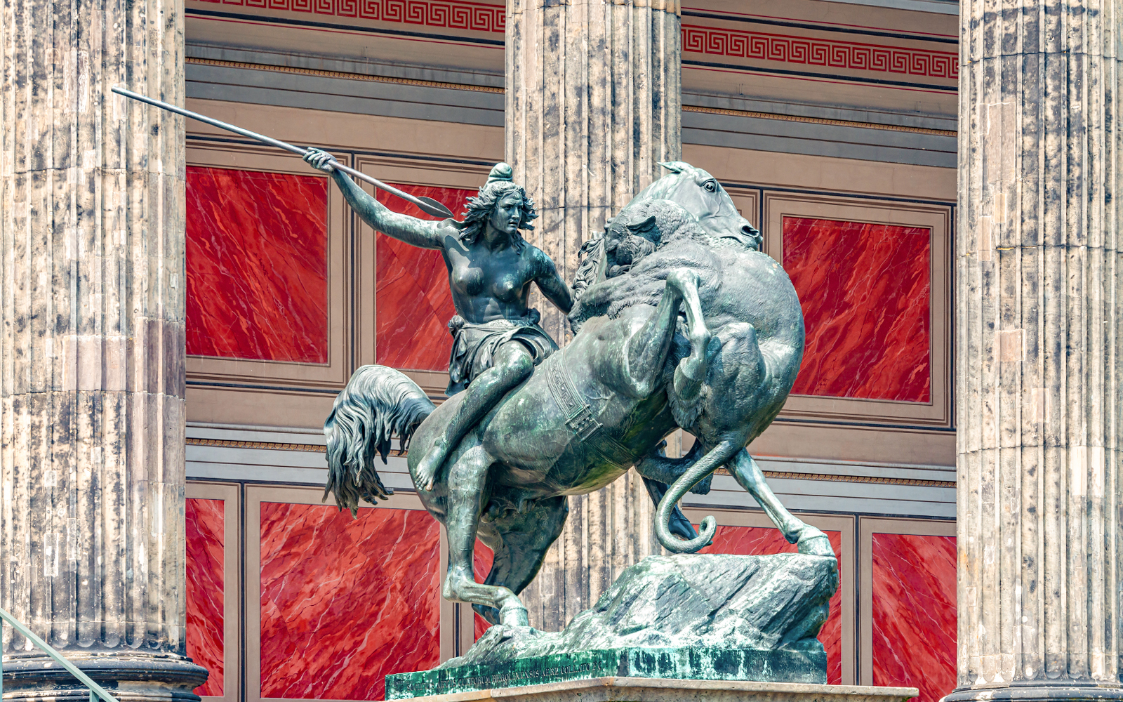 Ancient Roman statue of Amazonian woman on horseback with spear, attacked by lion, Altes History Museum.