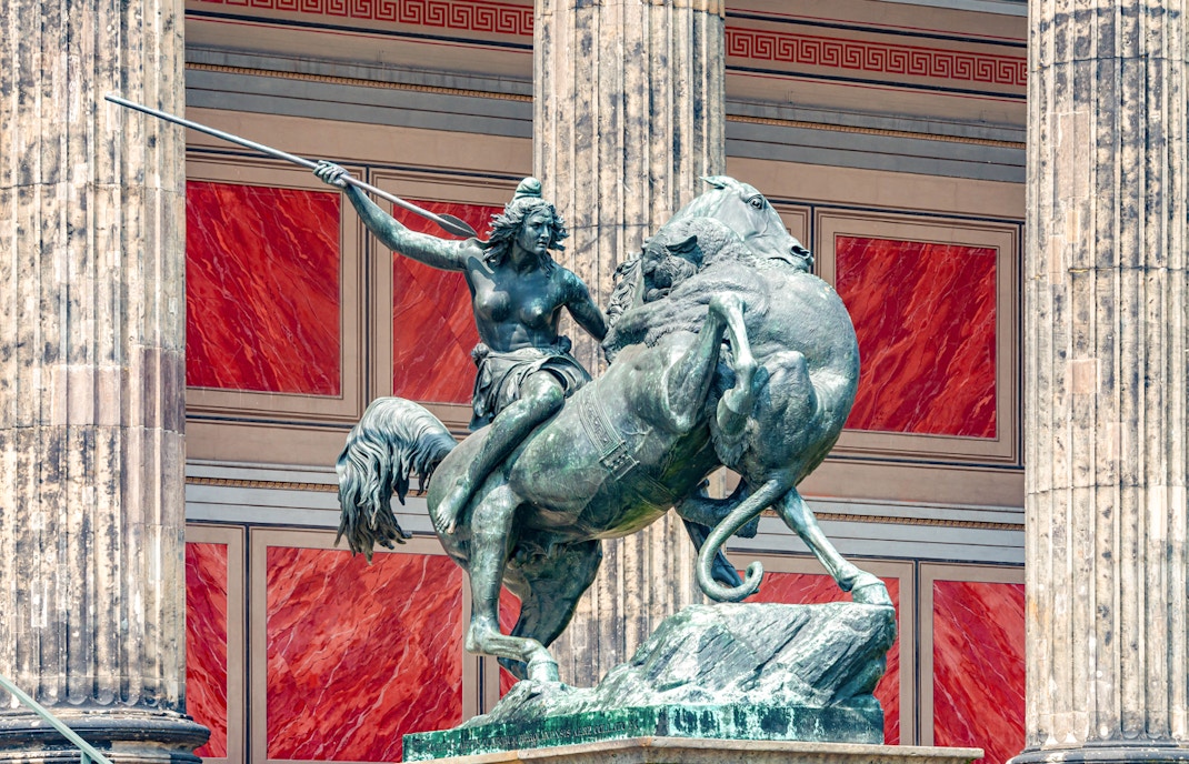 Ancient Roman statue of Amazonian woman on horseback with spear, attacked by lion, Altes History Museum.