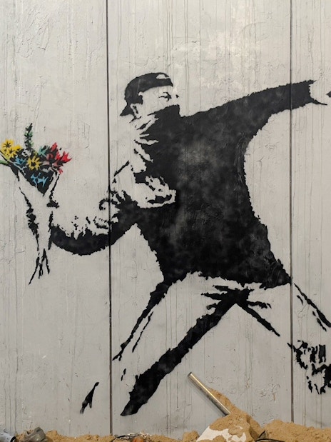 Protester mural holding flowers at Banksy Museum, Amsterdam.