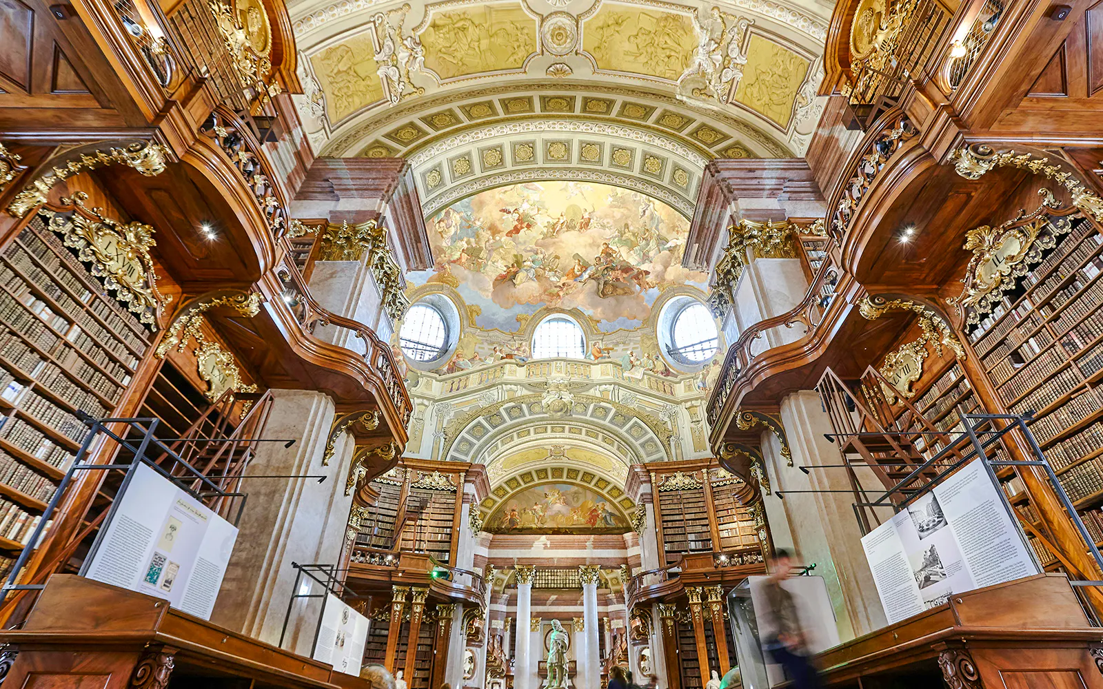 Austrian National Library State Hall with ornate baroque architecture and ceiling frescoes.